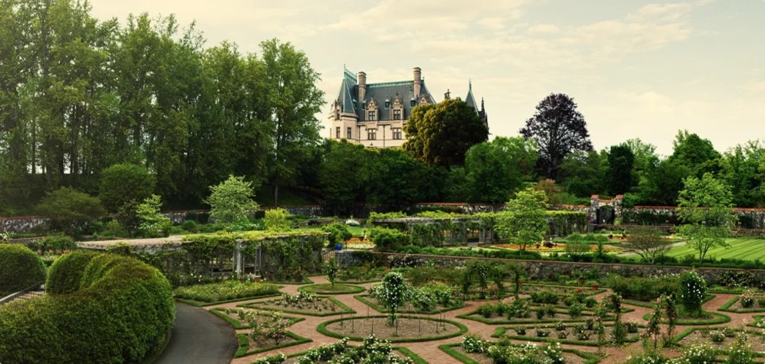 Ornate gardens are shown in the foreground, with the Biltmore mansion in the background