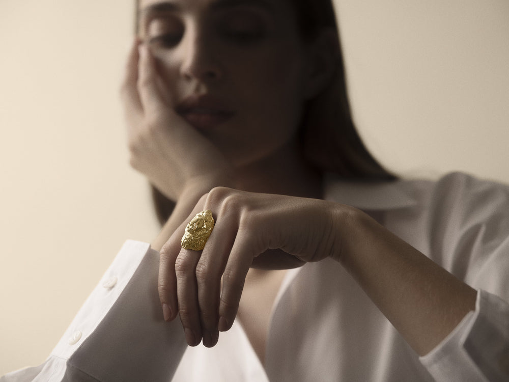 Close-up of a hand wearing a gold Commodore ring