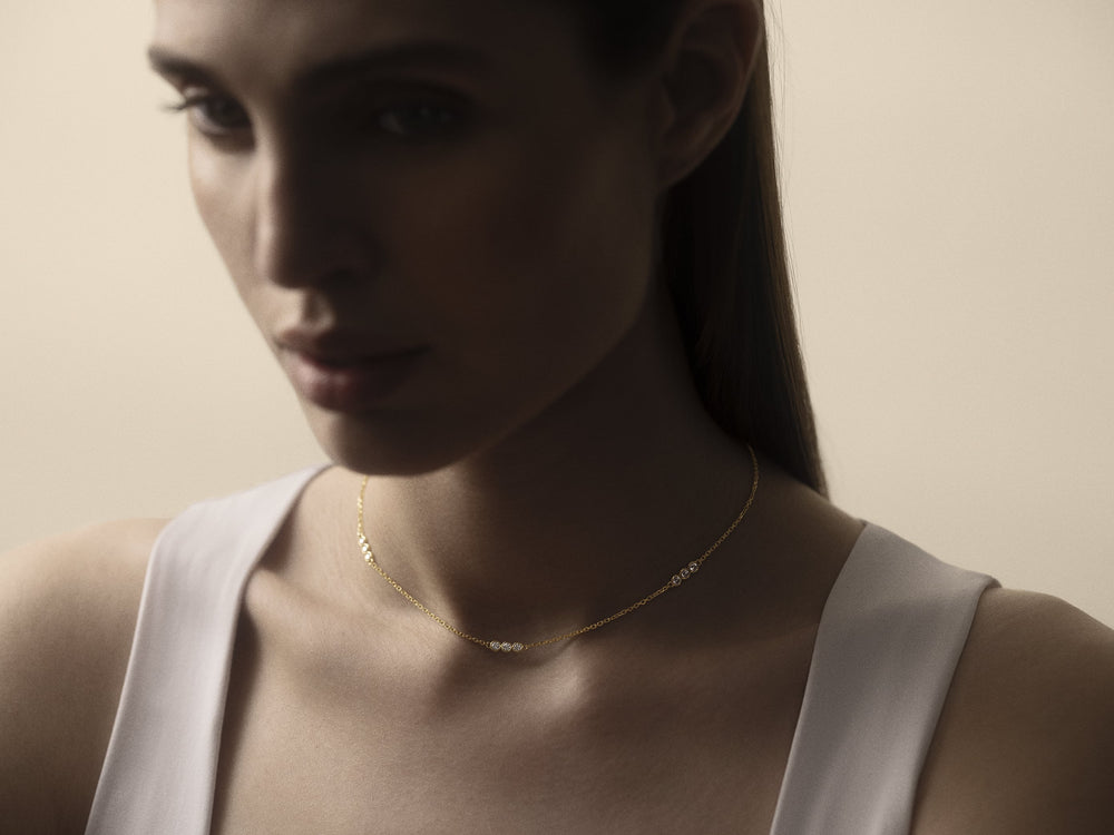 Portrait of a woman wearing a trio diamond necklace