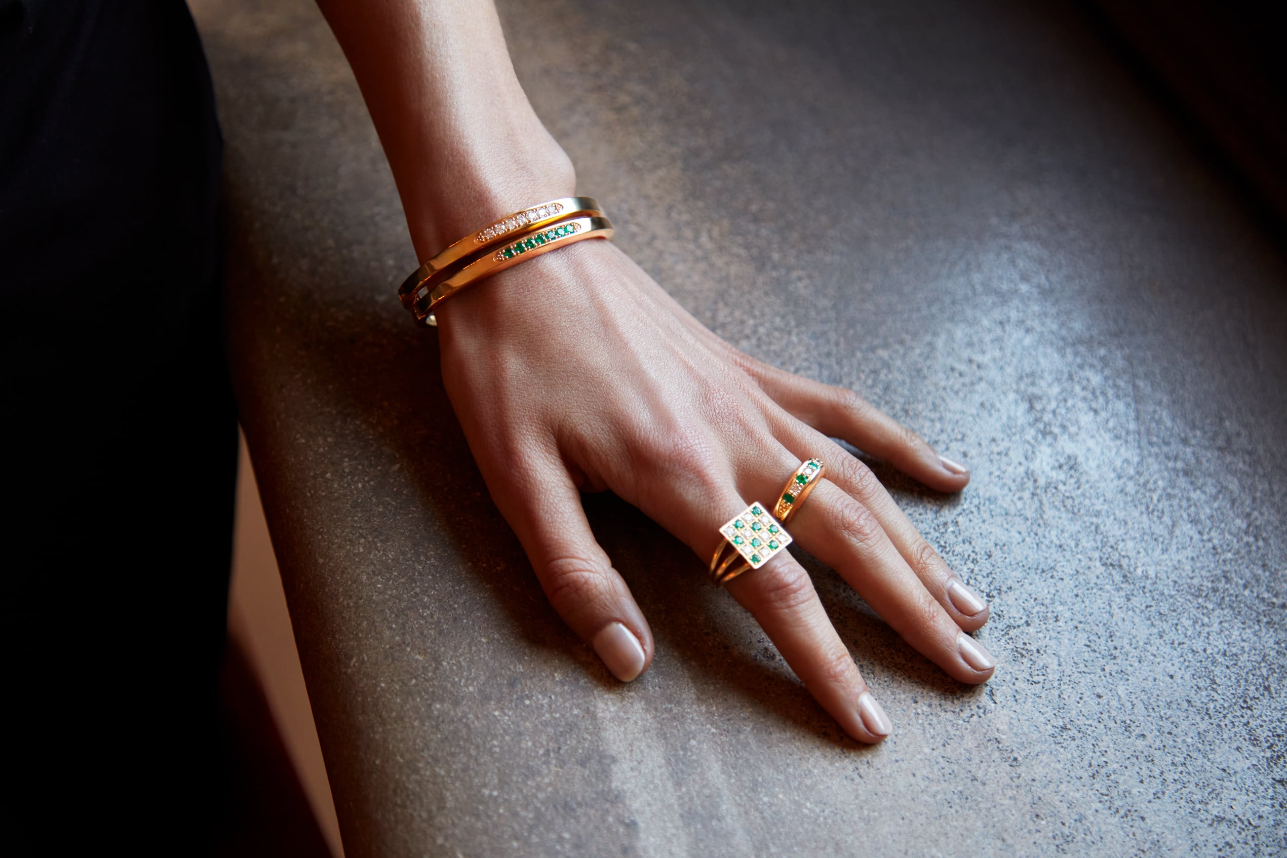 Close-up of a hand wearing Stuyvesant rings and bracelets
